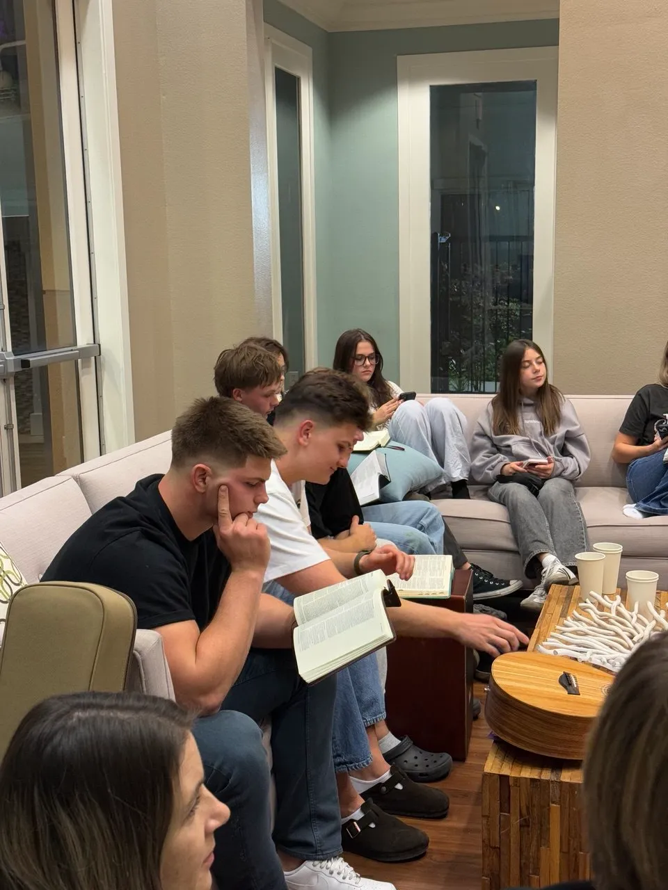 Young adults reading their Bibles together at a home group